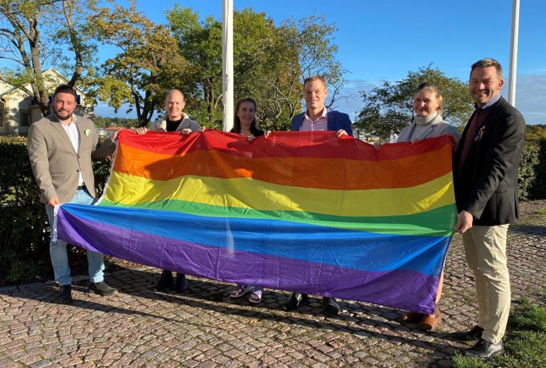 Representanter hissar regnbågsflaggan