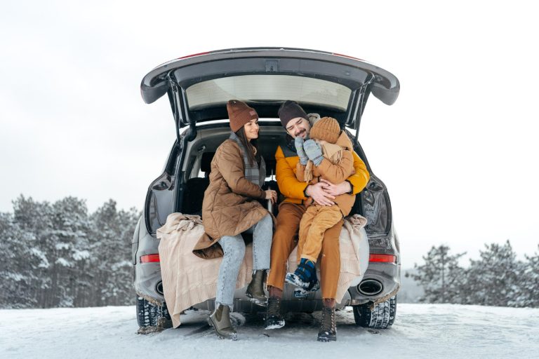 Familj sitter i bakluckan på bilen