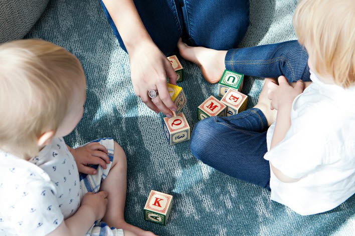 Mamma leker med klossar med mindre barn