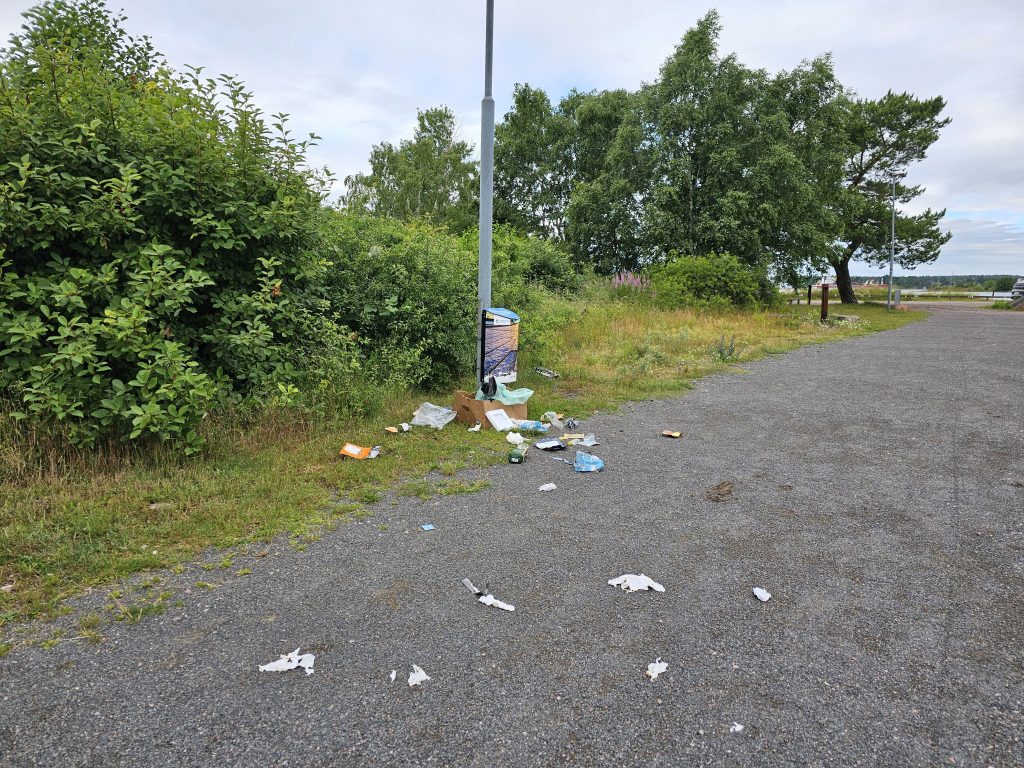 Nedskräpning vid papperskorg i Ernemar i Oskarshamn