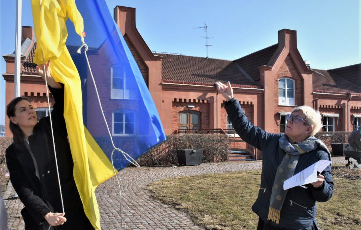 Maria Ihse, kommunikationschef i Oskarshamns kommun, och Yvonne Bergvall (S) hissar den ukrainska flaggan utanför stadshuset i Oskarshamn