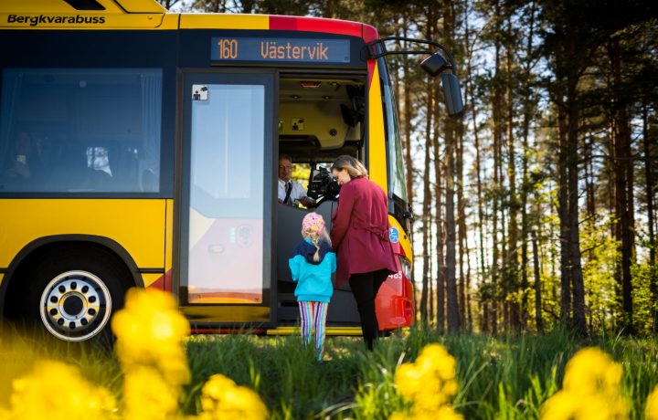 Personer går på en gul KLT-buss