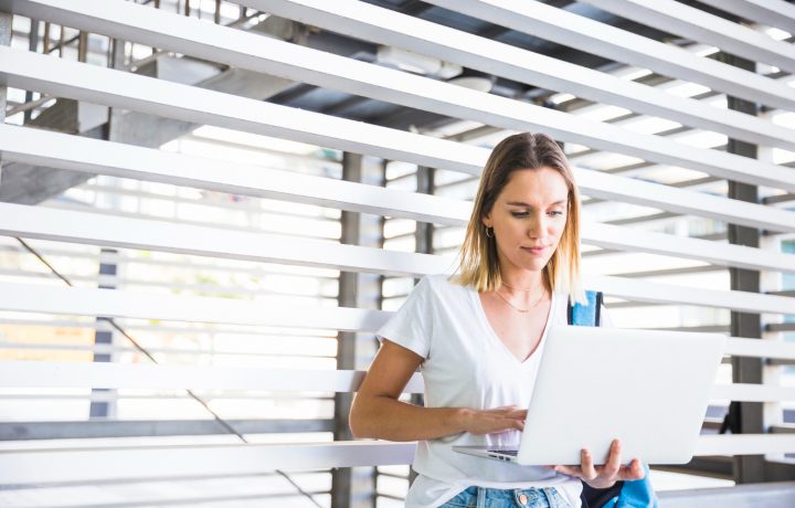 Ung kvinnlig student med laptop