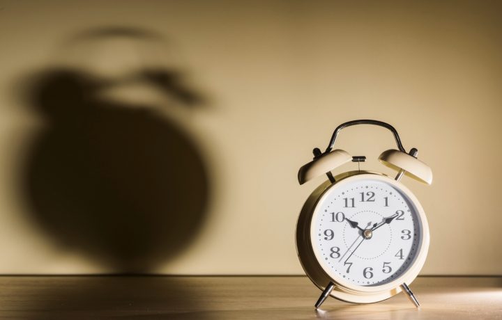 alarm-clock-wooden-desk-with-shadow-wall