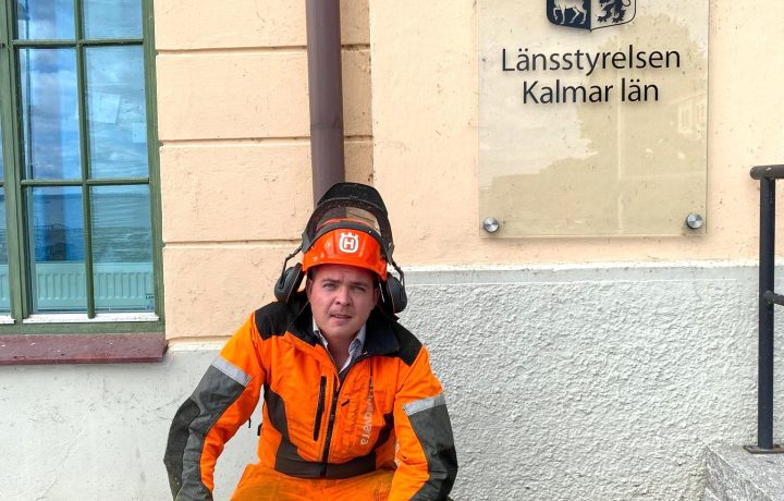 Carl-Wiktor Svensson (KD) i skogshuggarkläder vid länsstyrelsens entré i Kalmar