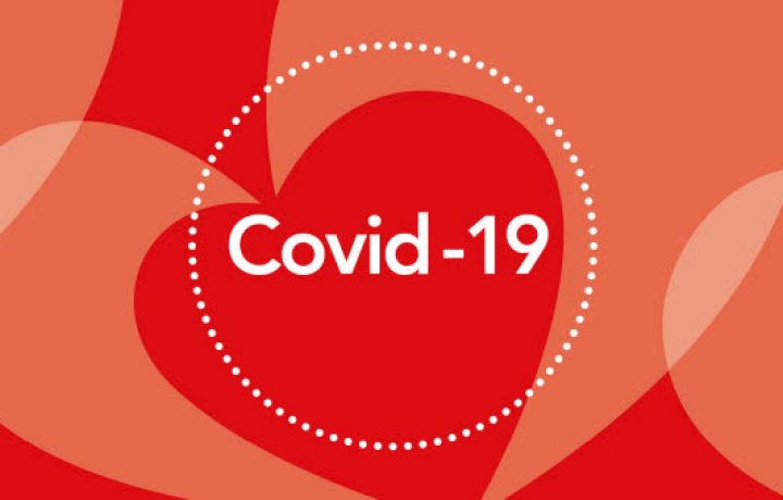 Covid-19 i cirkel med röda hjärtan som bakgrund