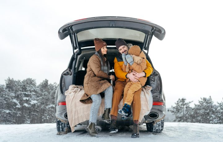 Familj sitter i bakluckan på bilen