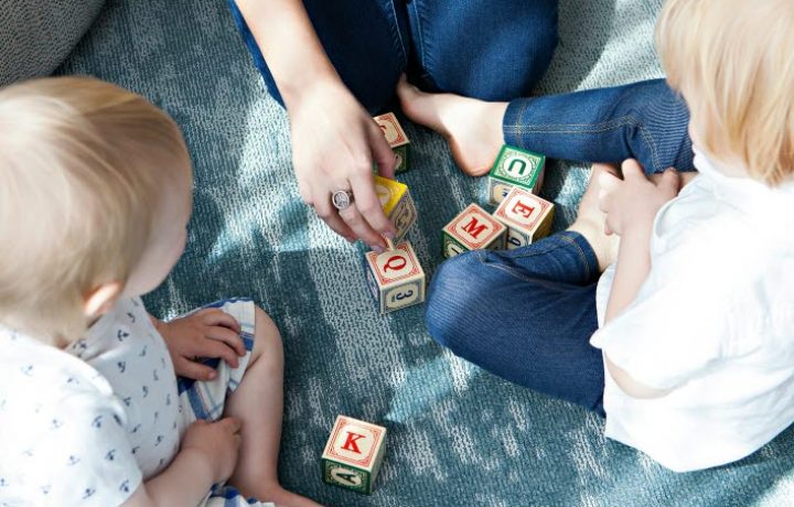 Mamma leker med klossar med mindre barn