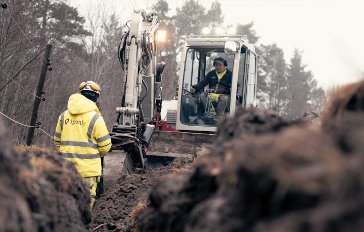 Grävmaskin som gräver ner fiber