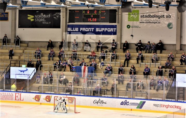 Publik på hockeymatch. Folk sitter med coronaavstånd på en ståplatsläktare i Oskarshamn.