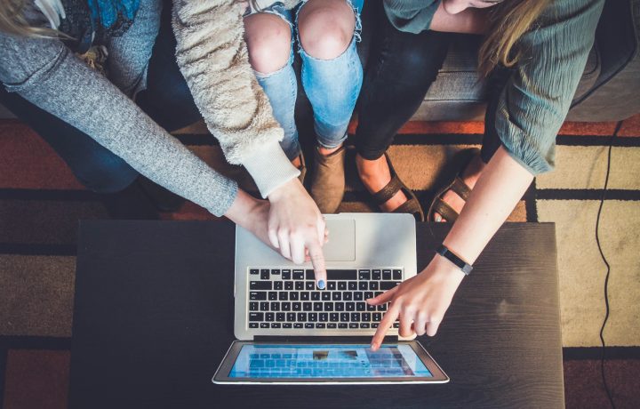 Personer som pekar på en laptop