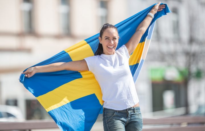 Kvinna håller svenska flaggan