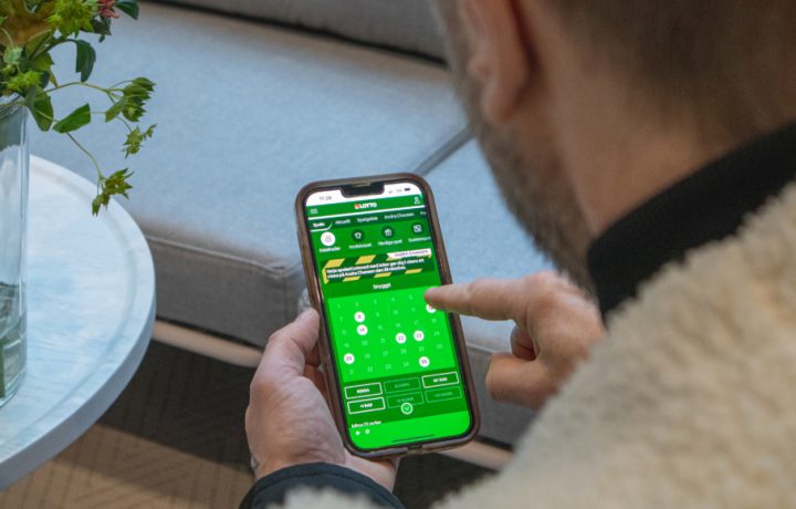 Man som tittar på mobilen med Lotto