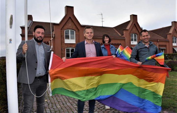 Representanter från Oskarshamns kommun hissar prideflaggan utanför stadshuset