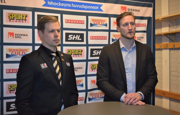 Två hockeytränare står och pratar på en pressträff