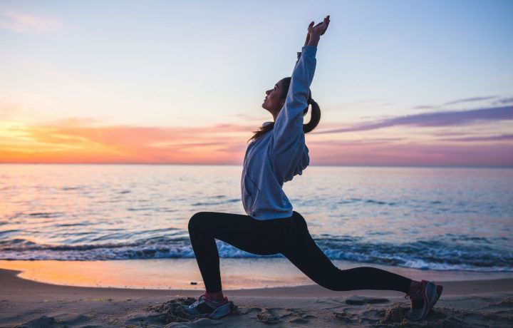 Kvinna gör yoga på stranden